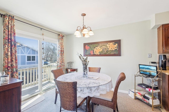 dining area with baseboards, light colored carpet, and a chandelier
