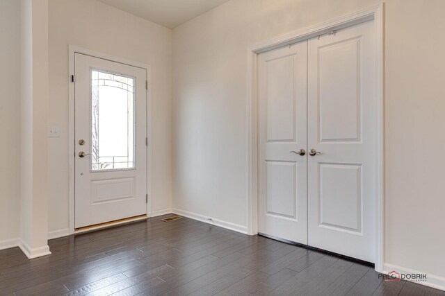 foyer featuring baseboards and dark wood-style flooring
