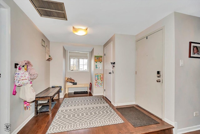 entryway with visible vents, dark wood-style flooring, and baseboards