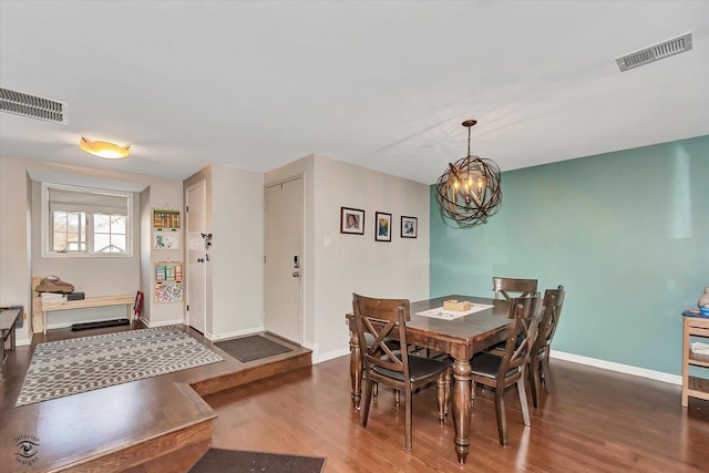 dining room featuring visible vents, a chandelier, wood finished floors, and baseboards
