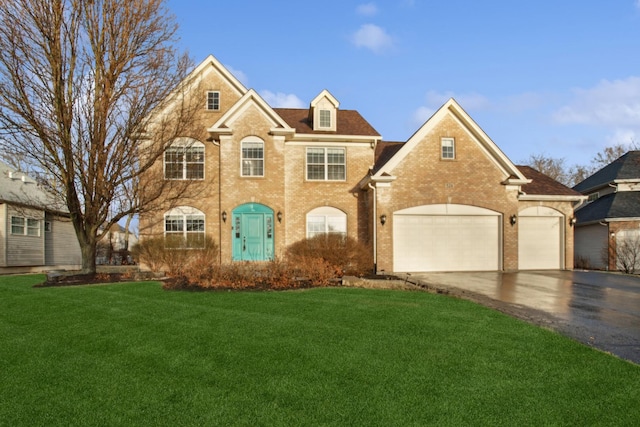 view of front of home featuring brick siding, driveway, an attached garage, and a front lawn