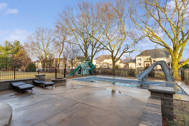 view of pool with playground community, a patio area, a water slide, and fence
