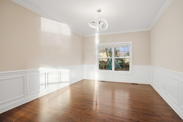 empty room featuring visible vents, an inviting chandelier, wood finished floors, and ornamental molding