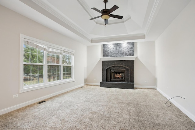 unfurnished living room featuring carpet, visible vents, a fireplace, ceiling fan, and crown molding