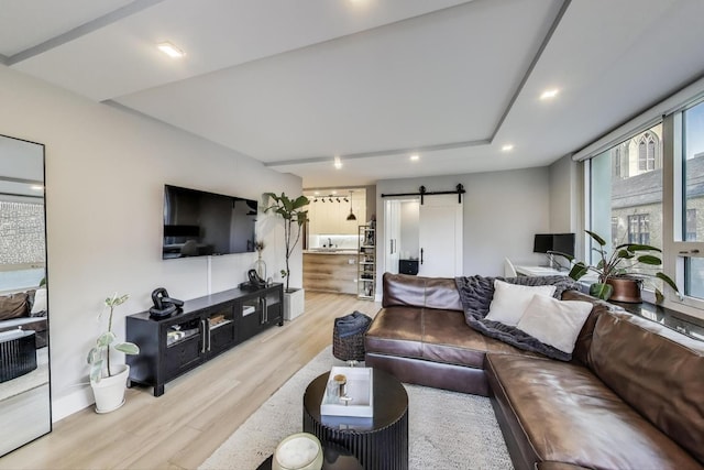 living room featuring a barn door, wood finished floors, and recessed lighting