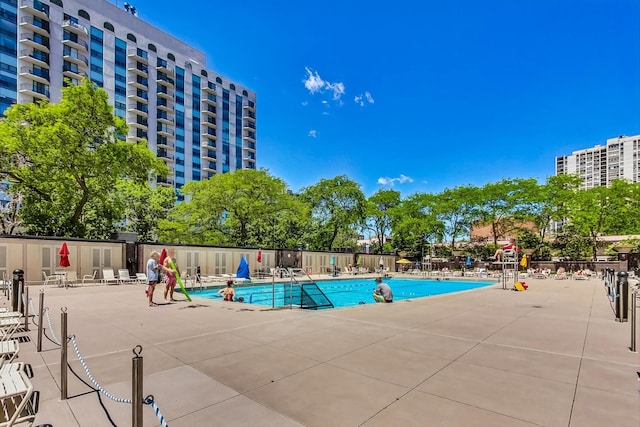 pool featuring fence and a patio area