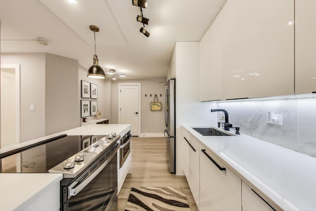 kitchen featuring white cabinetry, a sink, stainless steel appliances, and light countertops
