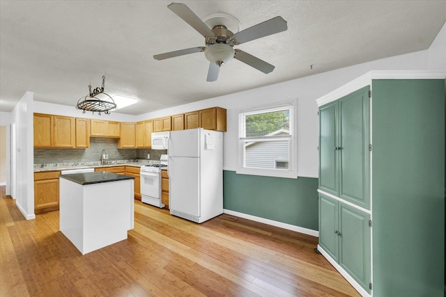 504 N 4th St, Saint Joseph, IL 61873 - kitchen featuring white appliances, light wood-type flooring, baseboards, a kitchen island, and a ceiling fan