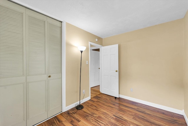 504 N 4th St, Saint Joseph, IL 61873 - unfurnished bedroom featuring baseboards, dark wood-style floors, and a closet