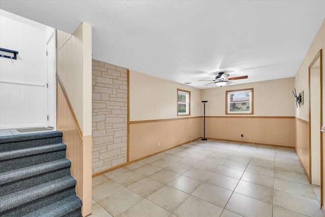 504 N 4th St, Saint Joseph, IL 61873 - empty room with a ceiling fan, stairway, wainscoting, light tile patterned floors, and a textured ceiling