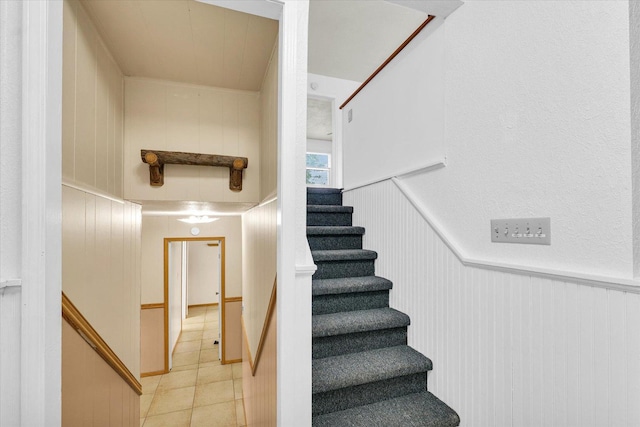 504 N 4th St, Saint Joseph, IL 61873 - staircase with tile patterned floors, a decorative wall, and a wainscoted wall