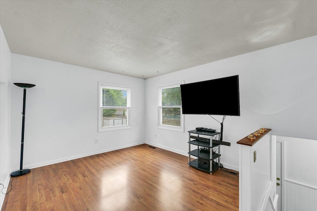 504 N 4th St, Saint Joseph, IL 61873 - unfurnished living room with wood finished floors, a textured ceiling, and baseboards