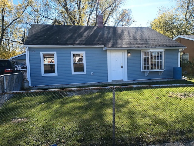 view of front of house with a chimney, a front yard, and fence