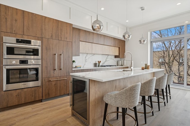 3951 N Wayne Ave Unit 404, Chicago, IL 60613 - kitchen with decorative backsplash, wine cooler, light wood-style floors, double oven, and modern cabinets