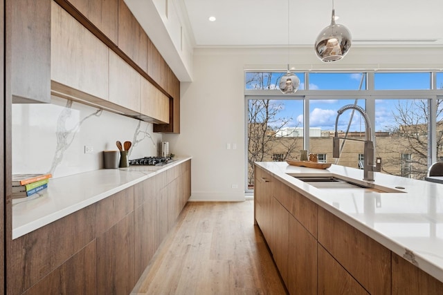 3951 N Wayne Ave Unit 404, Chicago, IL 60613 - kitchen featuring a sink, decorative backsplash, light countertops, light wood-style floors, and modern cabinets