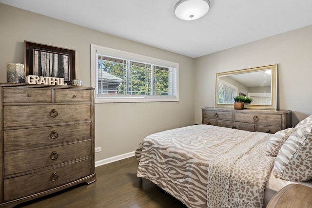 bedroom with baseboards and dark wood-type flooring