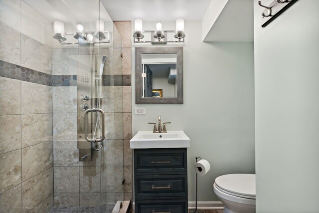 bathroom featuring vanity, a stall shower, and toilet
