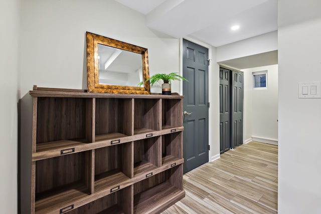 hall featuring baseboards, recessed lighting, and wood finished floors
