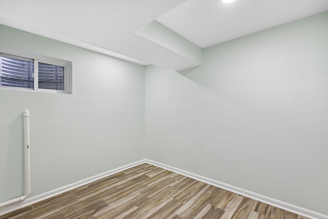 finished below grade area with baseboards and wood finished floors