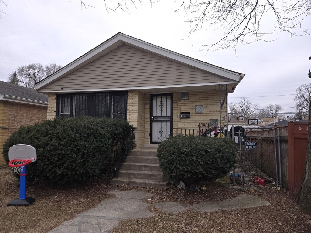 7254 S Paulina St, Chicago, IL 60636 - bungalow featuring brick siding, covered porch, and fence