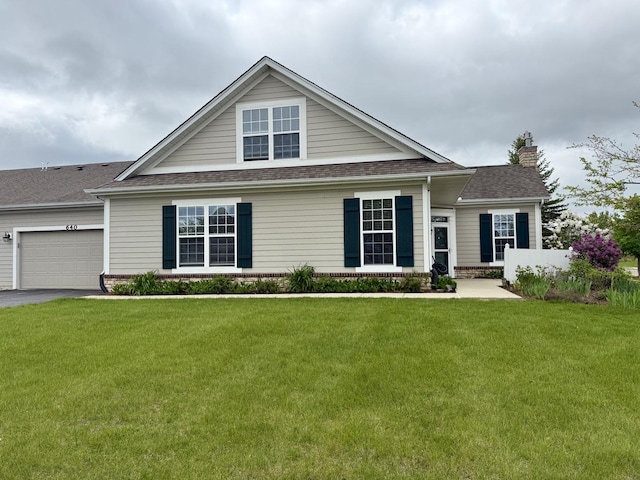 640 Schumann St, Woodstock, IL 60098 - view of front facade with a chimney, a front yard, asphalt driveway, and an attached garage