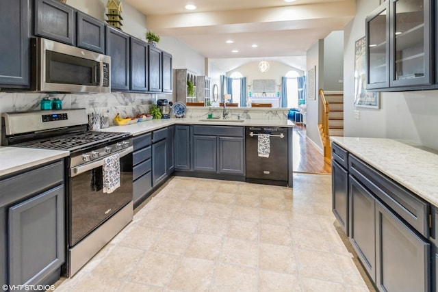 640 Schumann St, Woodstock, IL 60098 - kitchen featuring appliances with stainless steel finishes, a peninsula, light countertops, tasteful backsplash, and a sink