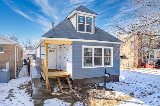 view of front of house featuring fence and a shingled roof