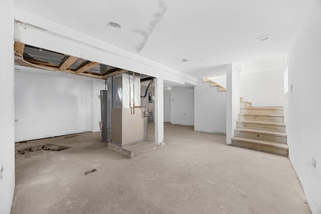 unfinished basement featuring heating unit and stairway
