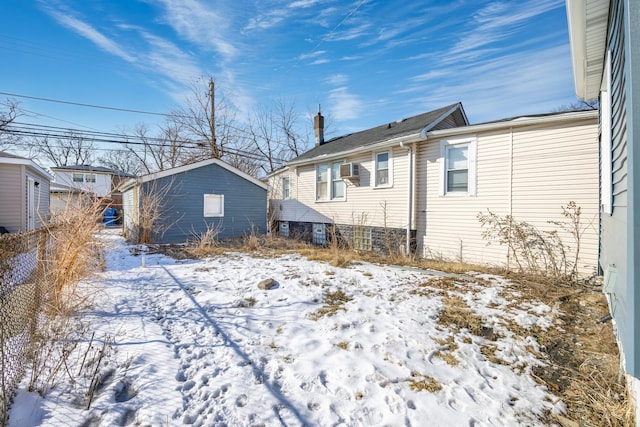 snow covered rear of property with fence