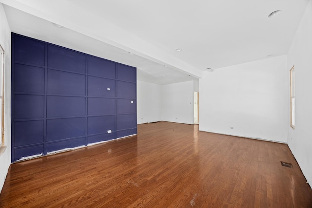 unfurnished room with visible vents and wood finished floors