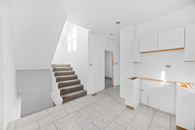 kitchen with light tile patterned floors and white cabinets