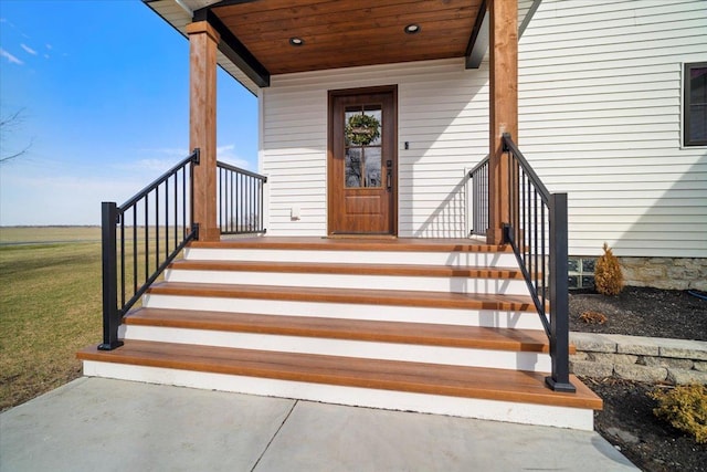 property entrance with covered porch and a yard