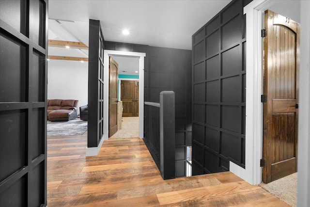 bathroom featuring wood finished floors, a decorative wall, and recessed lighting