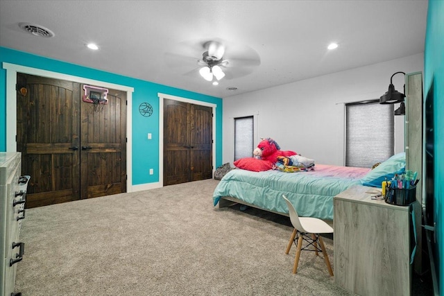 bedroom featuring carpet flooring, two closets, a ceiling fan, and recessed lighting
