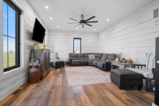 living room featuring recessed lighting, a ceiling fan, wood finished floors, and wood walls