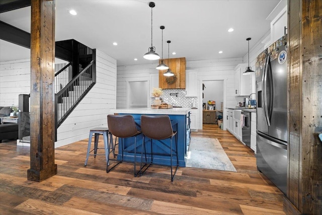 kitchen with stainless steel appliances, white cabinets, light countertops, a breakfast bar, and recessed lighting