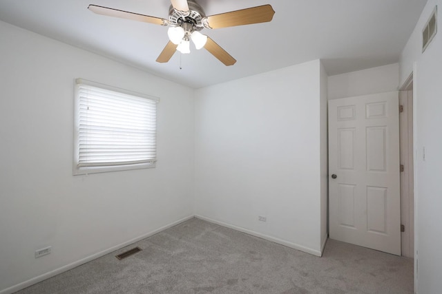 unfurnished room with light carpet, visible vents, baseboards, and ceiling fan