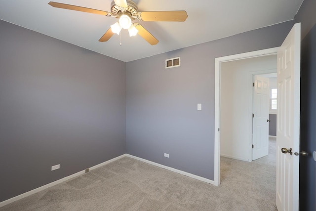 carpeted empty room featuring visible vents, baseboards, and a ceiling fan