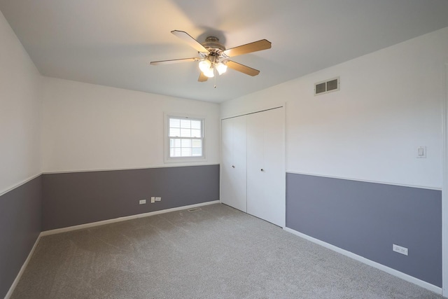 unfurnished bedroom featuring carpet, a closet, a ceiling fan, visible vents, and baseboards