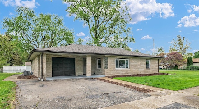 ranch-style house featuring stone siding, a garage, aphalt driveway, a front yard, and central AC unit
