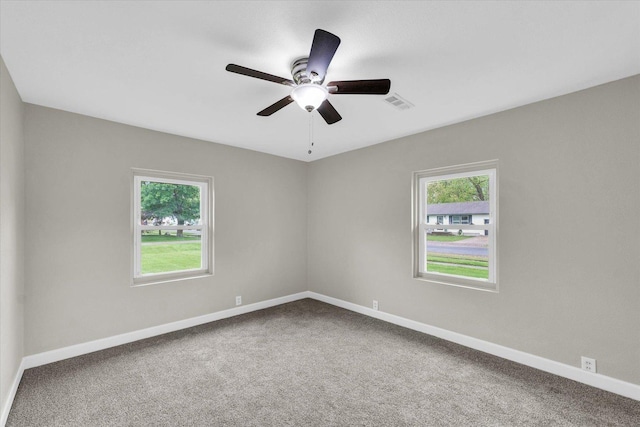 spare room featuring carpet floors, baseboards, and visible vents