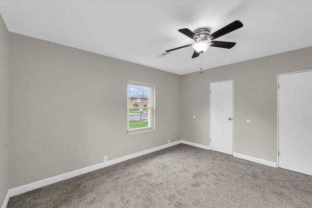 empty room featuring carpet flooring, ceiling fan, and baseboards
