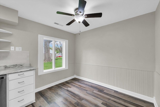 interior space featuring baseboards, ceiling fan, dark wood-style flooring, and visible vents