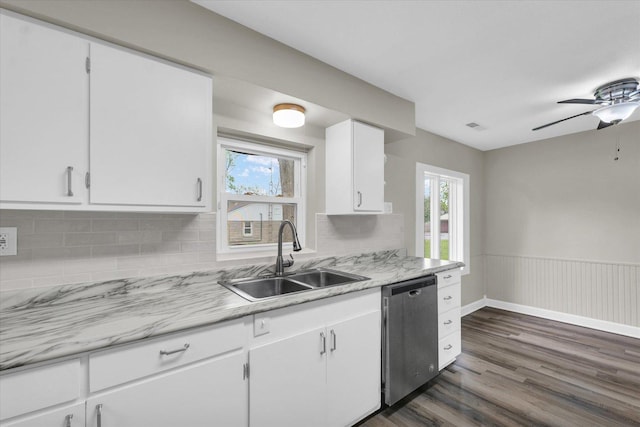 kitchen featuring ceiling fan, dishwasher, a sink, light countertops, and dark wood-style floors