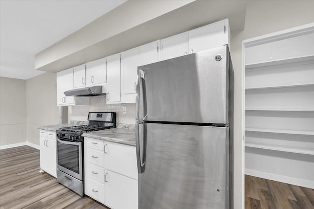 kitchen featuring stainless steel appliances, white cabinetry, wood finished floors, and under cabinet range hood