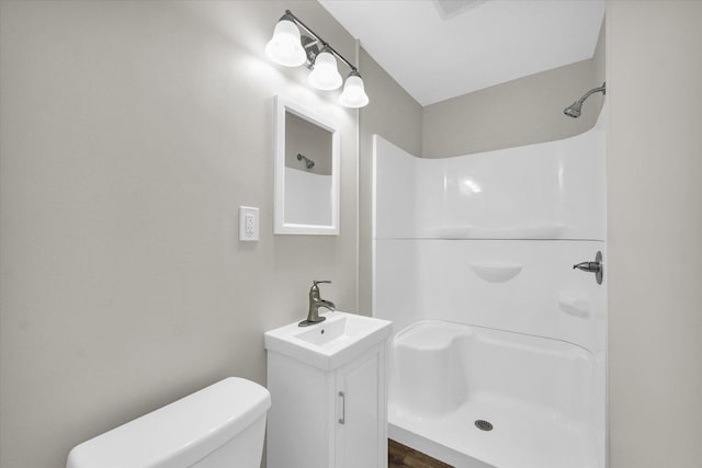bathroom with toilet, walk in shower, and vanity