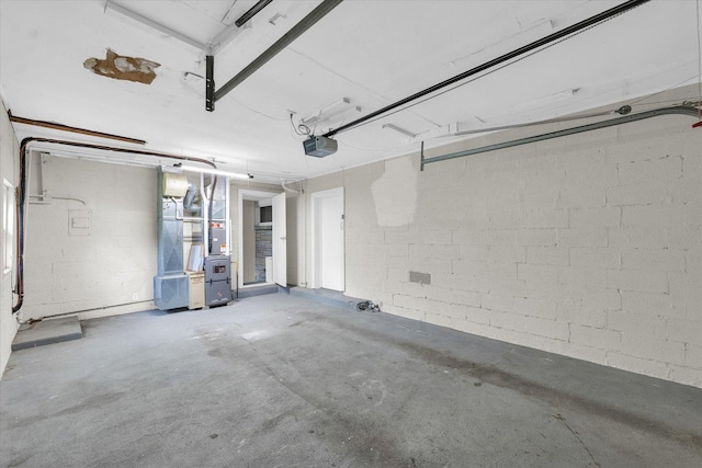 garage featuring heating unit and a garage door opener