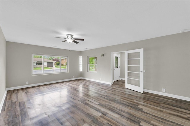 empty room featuring french doors, a healthy amount of sunlight, and wood finished floors