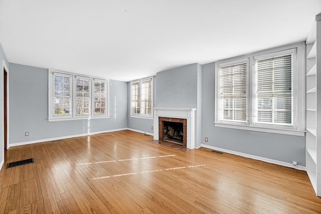 2242 Macdonald Ln, Flossmoor, IL 60422 - unfurnished living room with a tiled fireplace, baseboards, hardwood / wood-style flooring, and visible vents