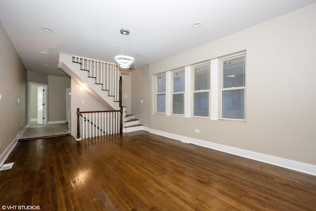 interior space with stairway, baseboards, an inviting chandelier, and hardwood / wood-style flooring